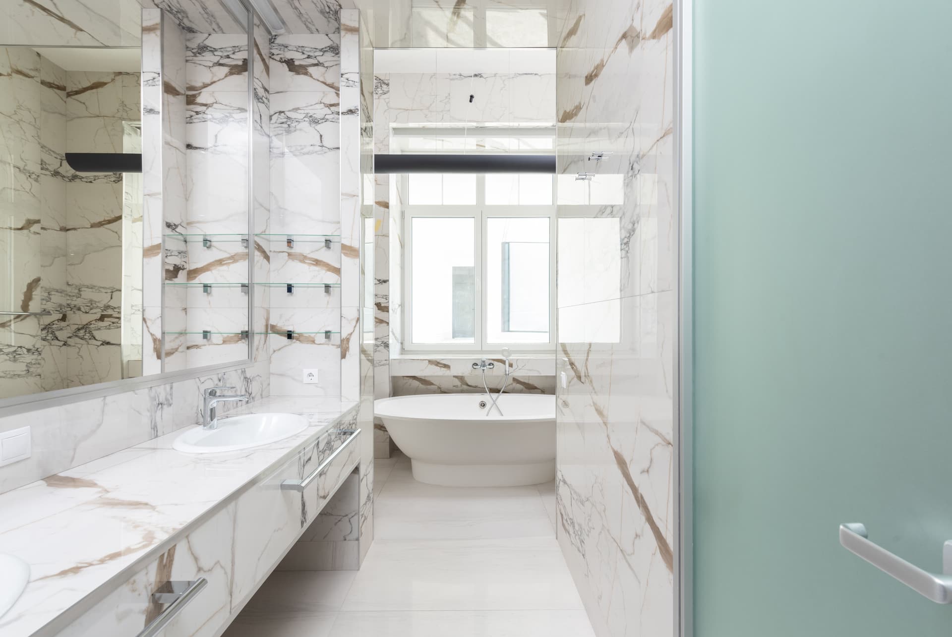 A marble bathroom with a freestanding bath and a double vanity.