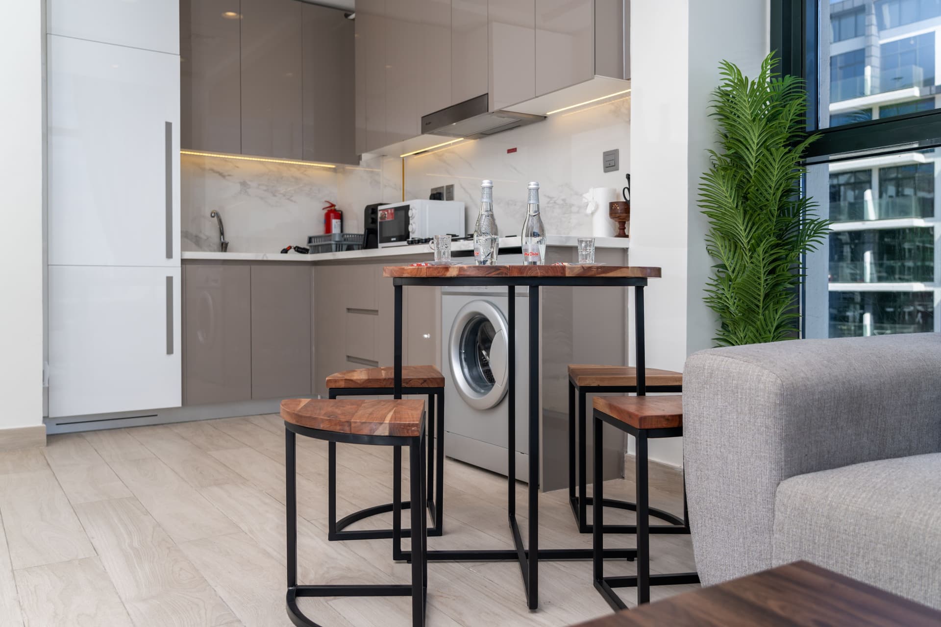 An apartment kitchen and dining corner with a breakfast bar and stools.